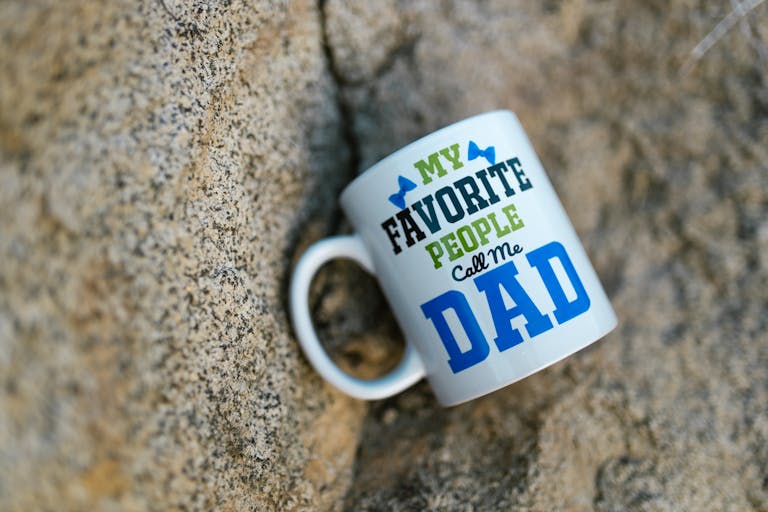 Ceramic mug with 'My Favorite People Call Me Dad' design on a stone background.