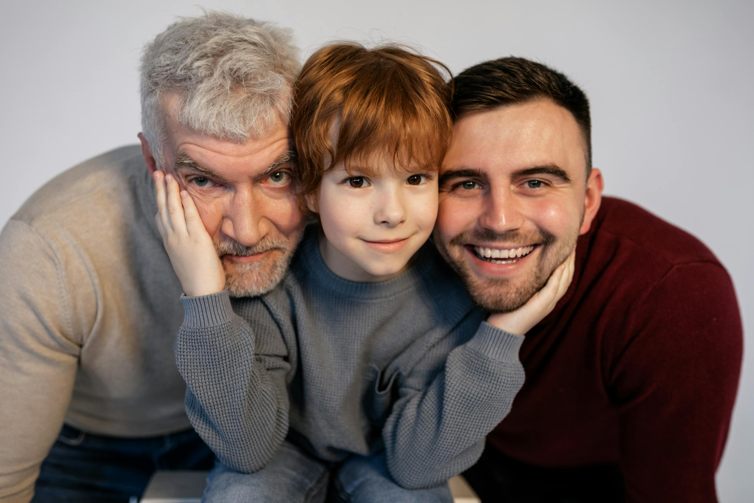 Portrait of three smiling generations, showcasing familial love and togetherness.